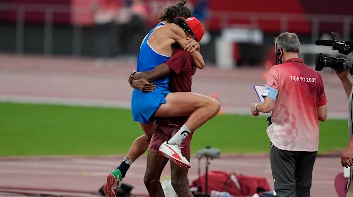 Gianmarco Tamberi (ITA) reacts after sharing gold with Mutaz Essa Barshim (QAT), center, in the men's high jump during the Tokyo 2020 Olympic Summer Games at Olympic Stadium.